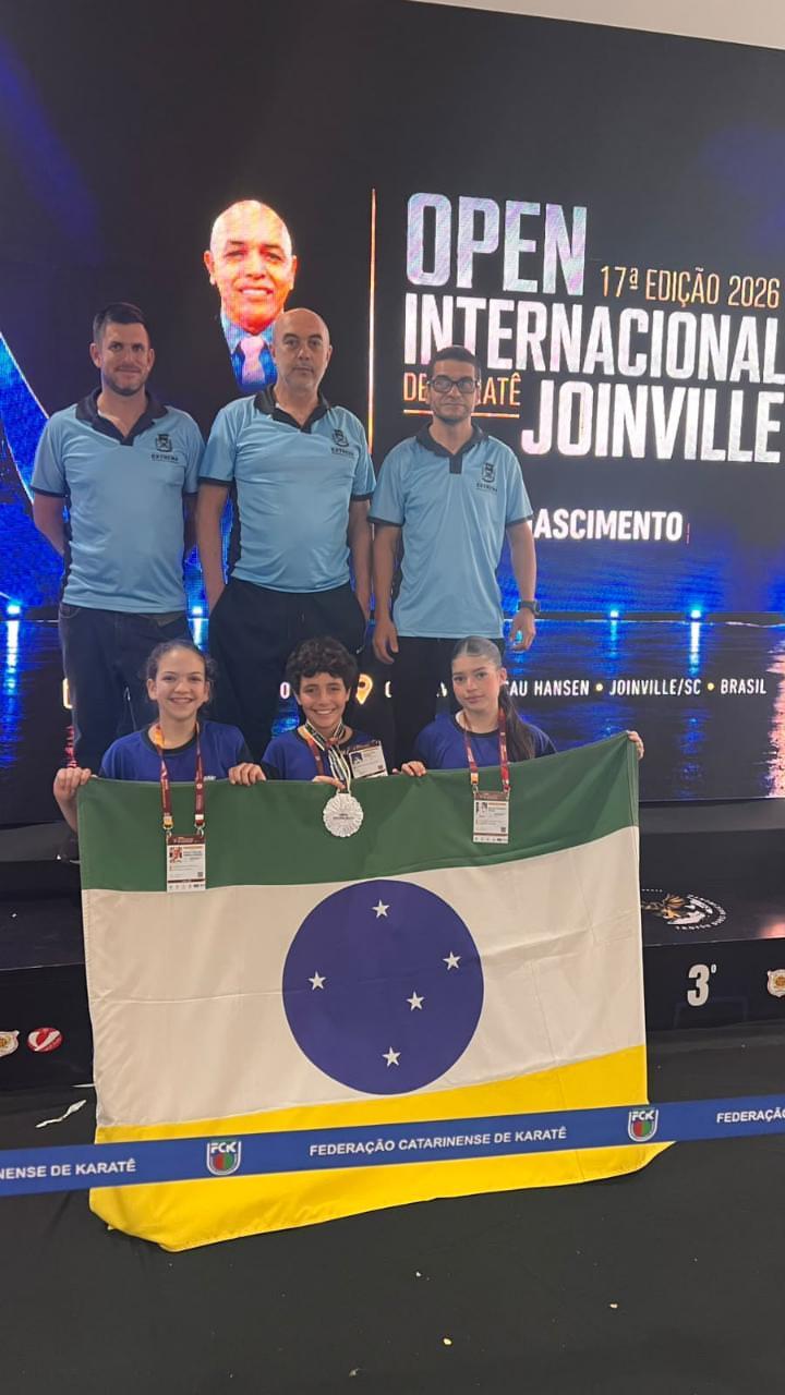 Atletas de Extrema de karatê com a bandeira do município e a medalha de prata no Open Internacional de Joinville